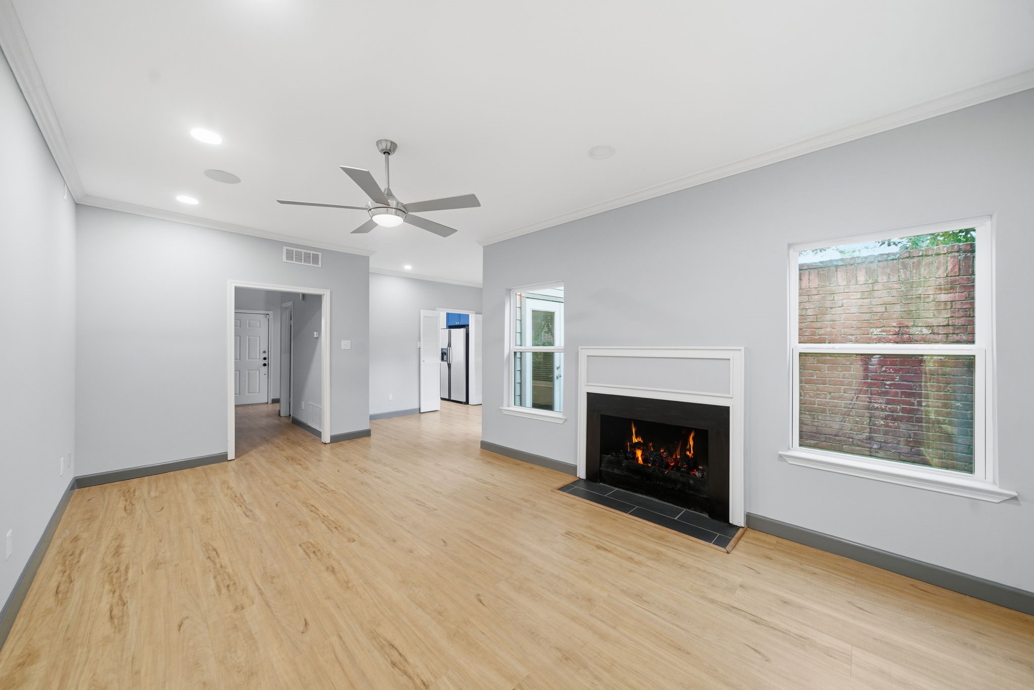 7447 Cambridge Street, Unit 65 Houston, TX 77054 - Photo 13 of 42 a view of an empty room with wooden floor fireplace and a window