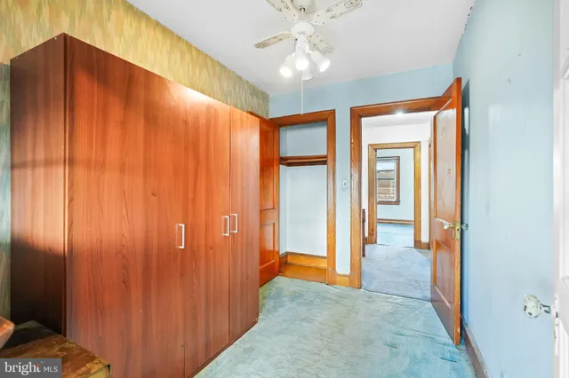 a view of a hallway with a chandelier fan