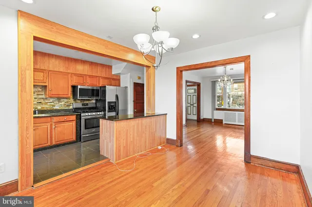 a kitchen with stainless steel appliances kitchen island granite countertop a stove and cabinets