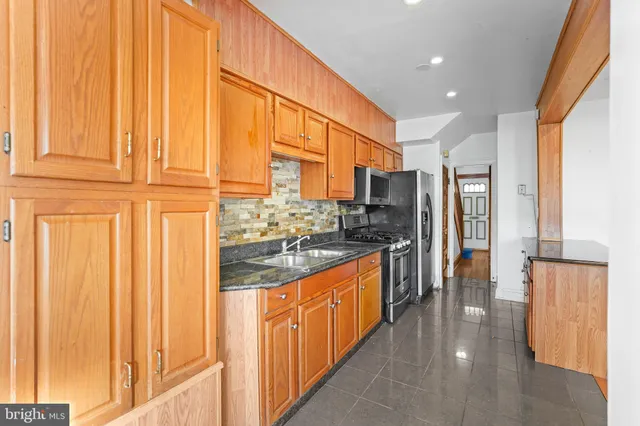 a kitchen with stainless steel appliances granite countertop a refrigerator and a stove top oven