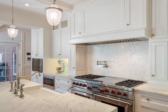 a kitchen with stainless steel appliances granite countertop a stove and a white cabinets