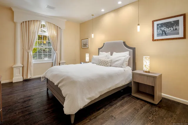 a large bed sitting in a bedroom next to a window