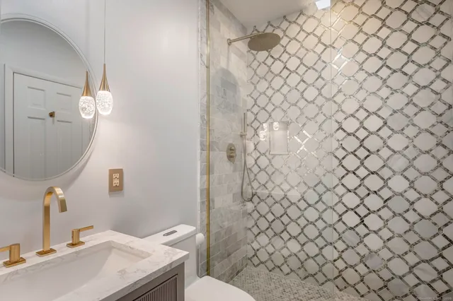 a bathroom with a sink a toilet and a mirror