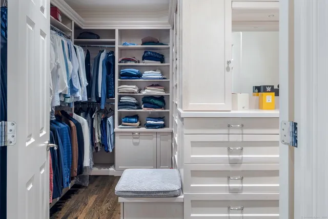 a view of walk in closet with clothes and shoes