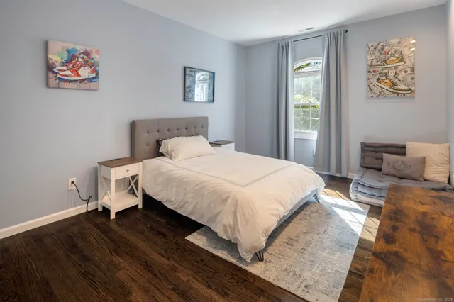 a bedroom with a bed and a painting on the wall