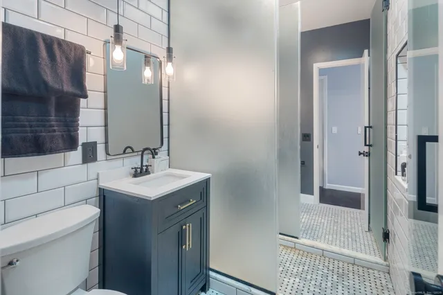 a bathroom with a sink a toilet and shower