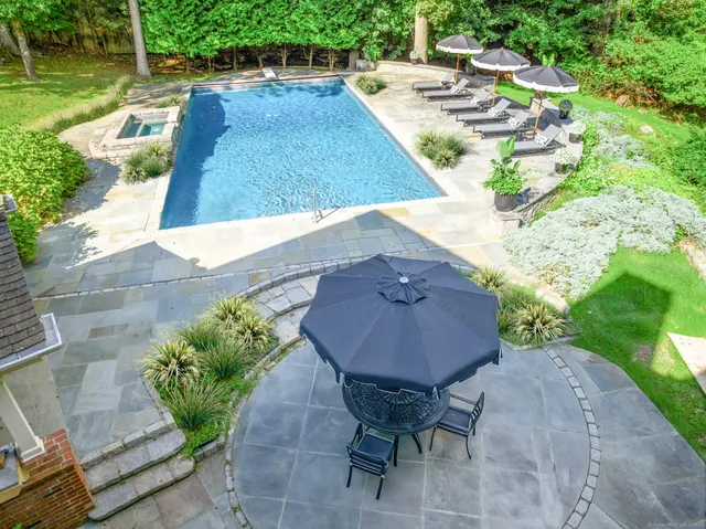a view of a backyard with table and chairs under an umbrella