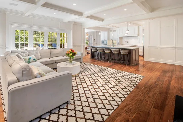 a living room with stainless steel appliances kitchen island granite countertop furniture and a large window