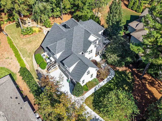 an aerial view of residential house with outdoor space and trees all around