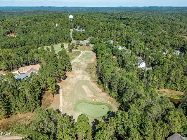 an aerial view of lake residential house with outdoor space and trees all around