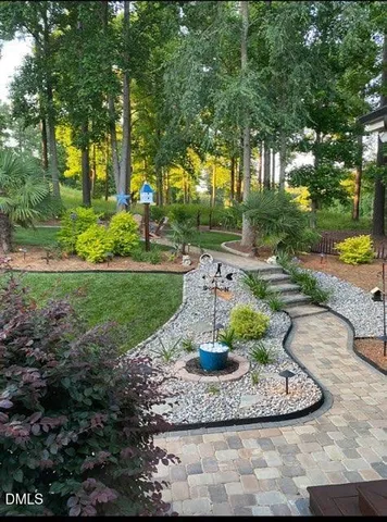 a kitchen with a sink dishwasher and white cabinets with wooden floor