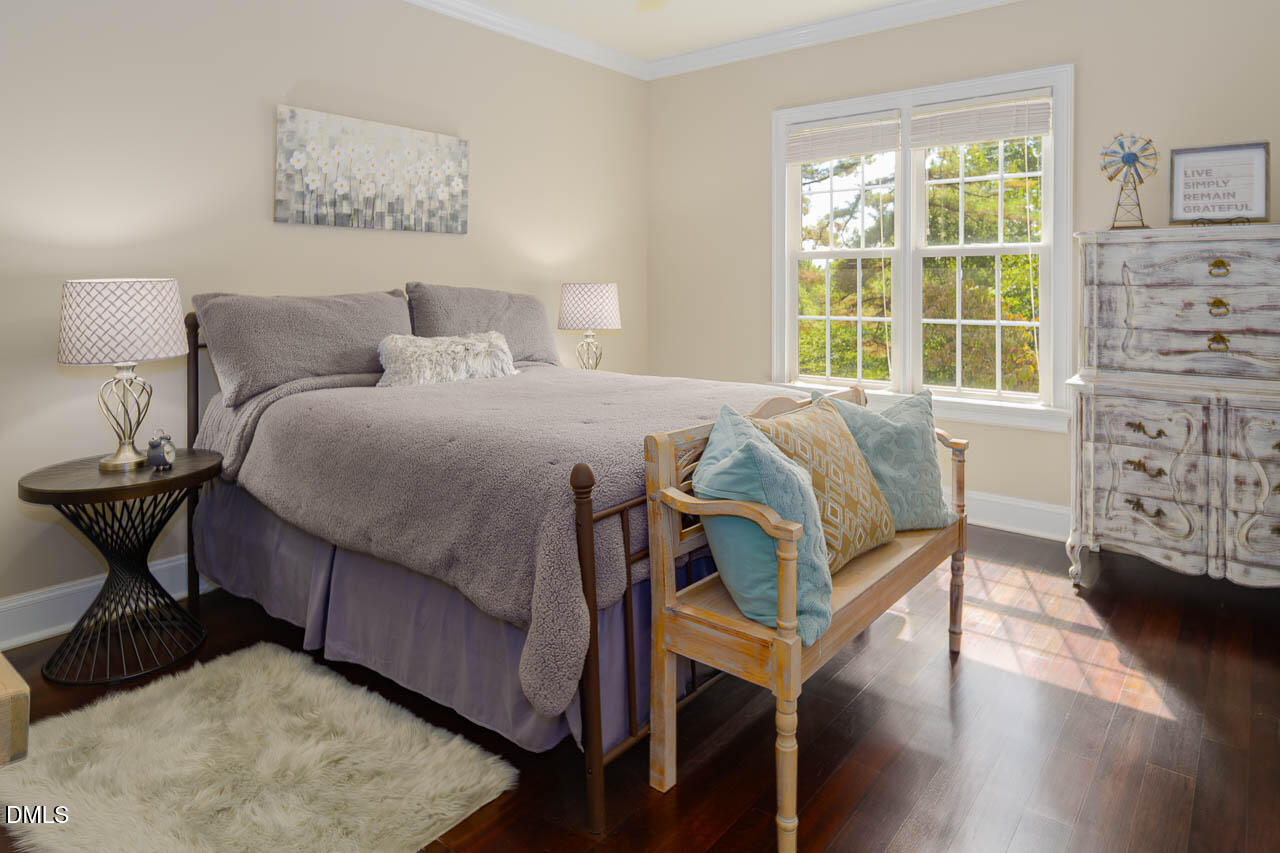 316 Chapel Ridge Drive Pittsboro, NC 27312 - Photo 52 of 69 a bedroom with a bed a table and chair with wooden floor