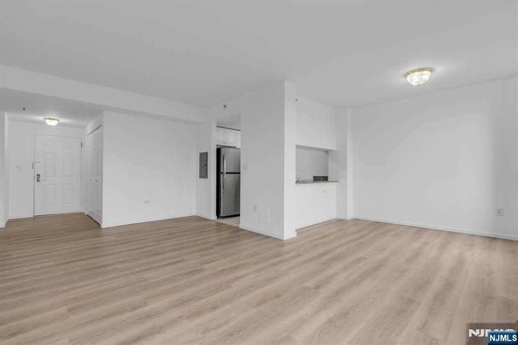 100 Old Palisade Road, Unit 1814 Fort Lee, NJ 07024 - Photo 4 of 23 a view of an empty room with wooden floor and kitchen