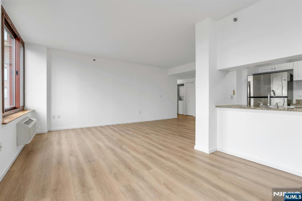 100 Old Palisade Road, Unit 1814 Fort Lee, NJ 07024 - Photo 5 of 23 a view of kitchen and empty room with wooden floor