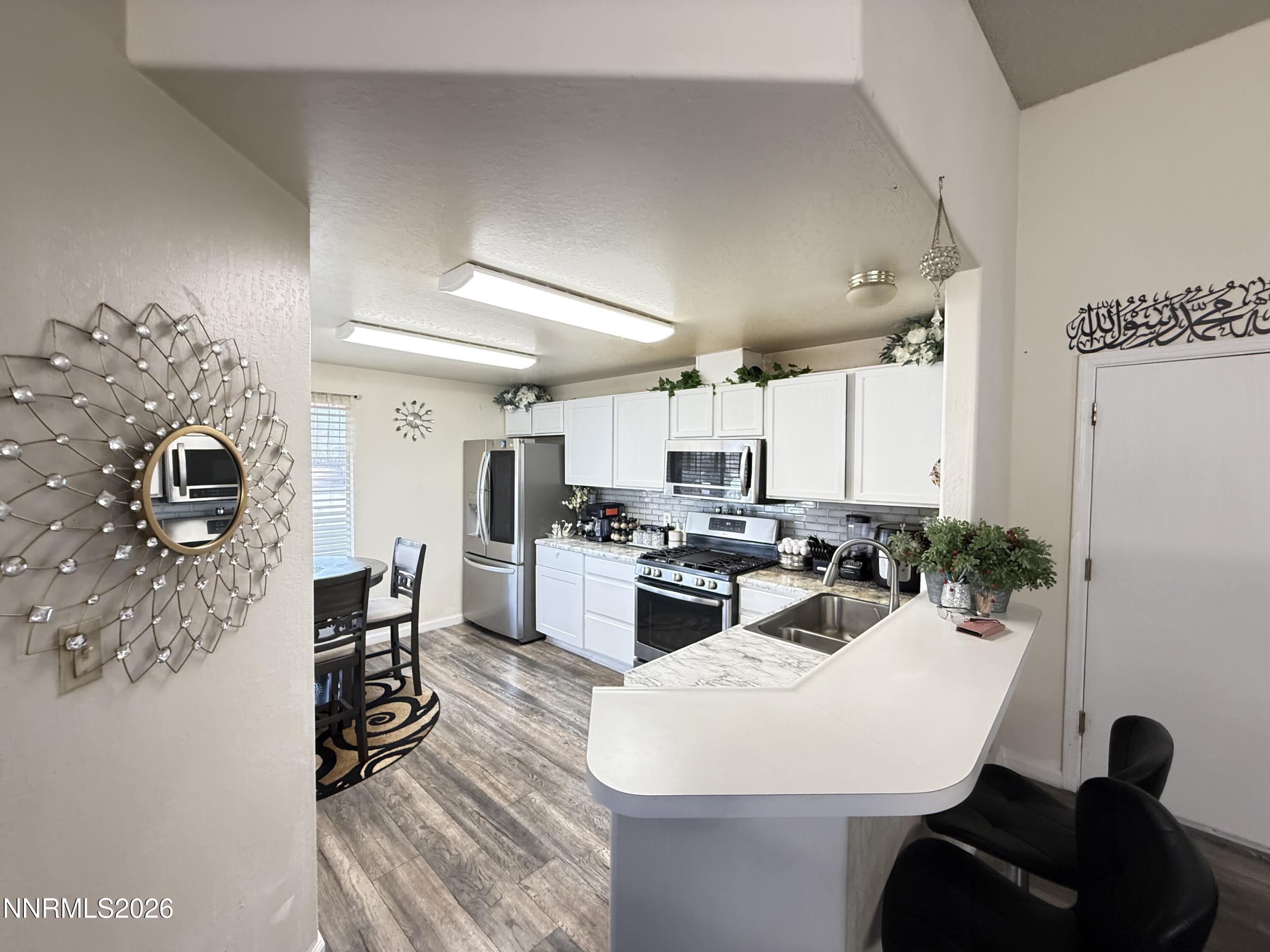 1585 Mescalero Avenue Reno, NV 89523 - Photo 5 of 13 a kitchen with sink refrigerator dining table and chairs
