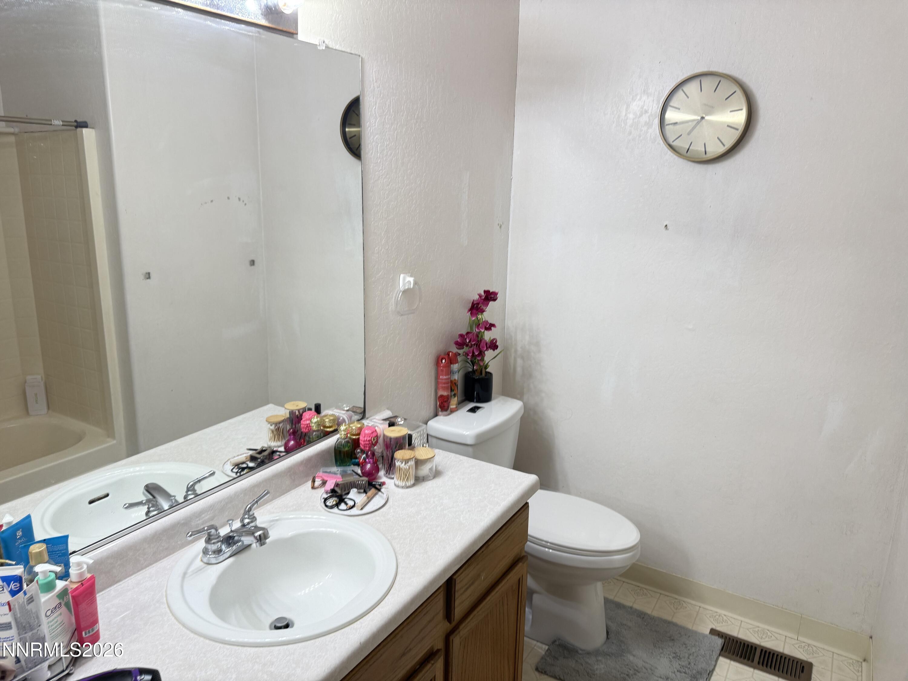 1585 Mescalero Avenue Reno, NV 89523 - Photo 7 of 13 a bathroom with a sink a toilet and a mirror
