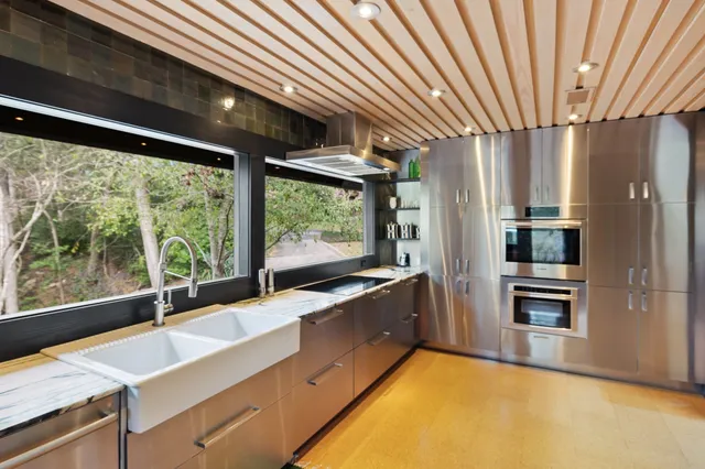 a kitchen with stainless steel appliances granite countertop sink stove and refrigerator