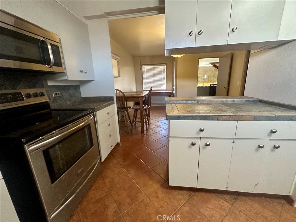 1602 Collins Street Needles, CA 92363 - Photo 12 of 18 a kitchen with stainless steel appliances granite countertop a stove a microwave and a sink