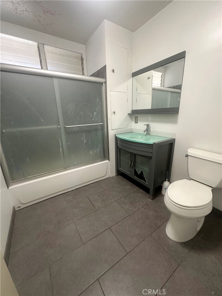 1602 Collins Street Needles, CA 92363 - Photo 16 of 18 a bathroom with a toilet a sink and mirror