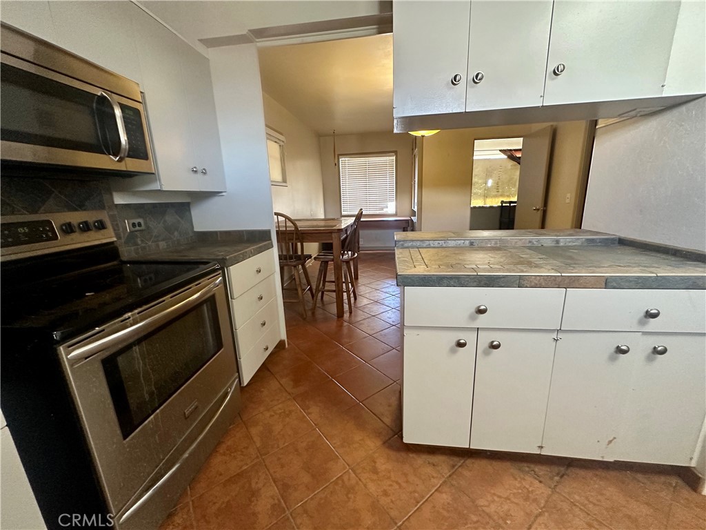 1602 Collins Street Needles, CA 92363 - Photo 7 of 18 a kitchen with stainless steel appliances granite countertop a stove a microwave and a sink