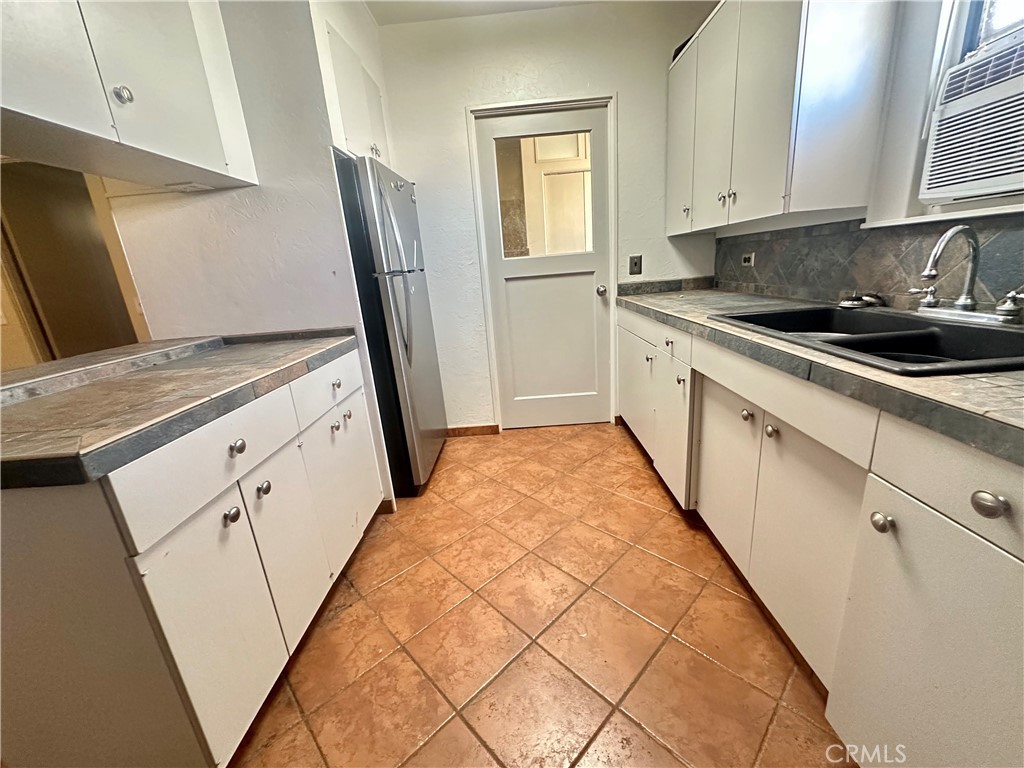 1602 Collins Street Needles, CA 92363 - Photo 8 of 18 a kitchen with granite countertop white cabinets and white appliances