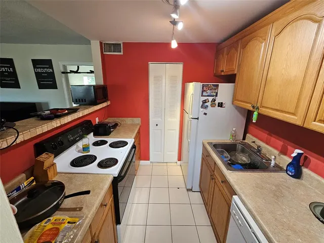 a kitchen with a stove a refrigerator and a sink