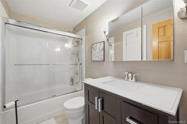 a bathroom with a sink a toilet and shower