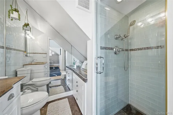 a bathroom with a granite countertop sink toilet and shower