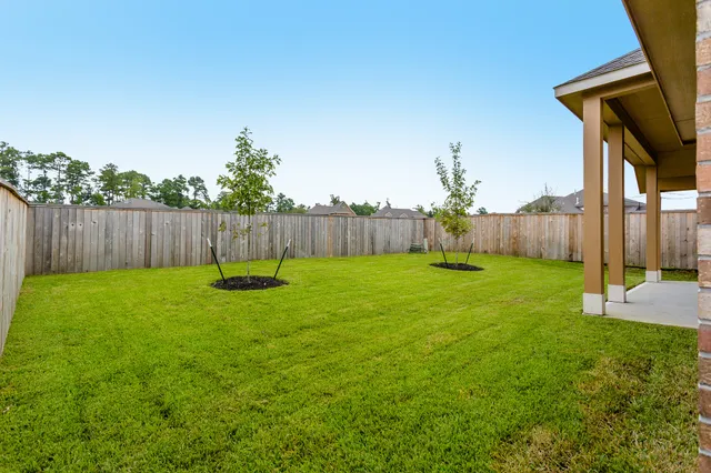 a view of a backyard with table and chairs and wooden fence