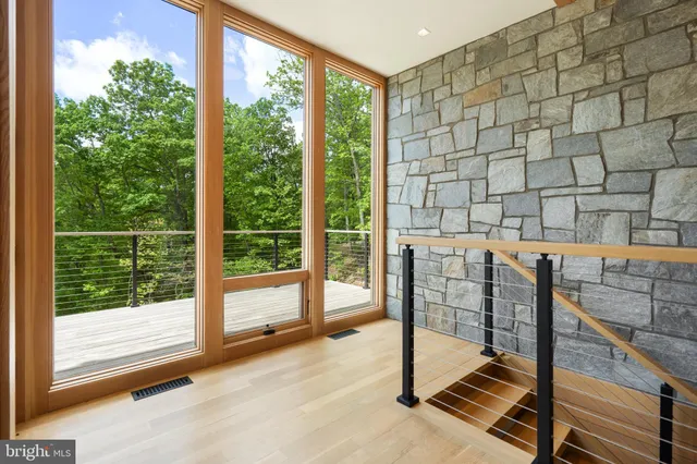 a living room with furniture a ceiling fan and a large window