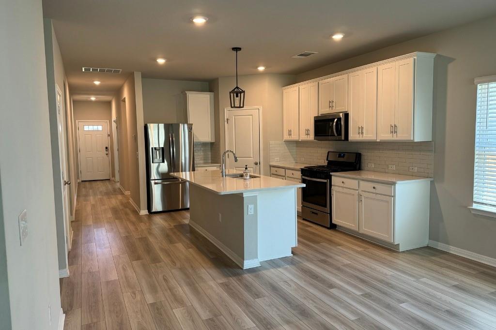 12604 Dairywork Road Buda, TX 78610 - Photo 3 of 20 A well-appointed kitchen showcasing a central island and a full suite of stainless steel appliances.