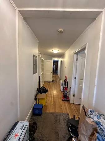 a room with lots of white furniture and wooden floor