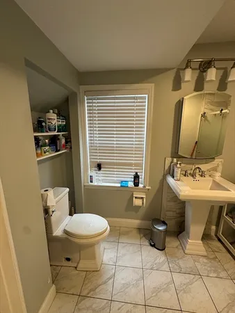 a bathroom with a sink toilet and mirror