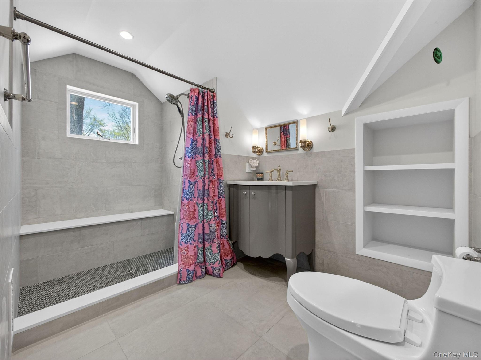 98 Greenbush Road Tappan, NY 10983 - Photo 20 of 33 Sloped ceiling bathroom featuring a tiled walk-in shower with a built-in bench and a window