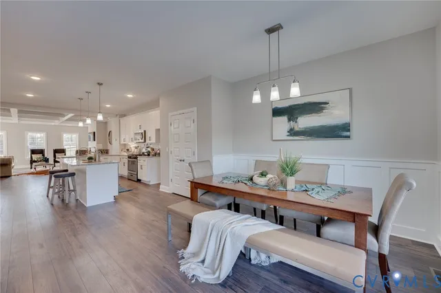 a dining room with furniture a kitchen and chandelier