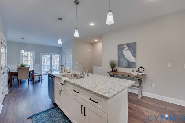 a view of a kitchen counter space a sink wooden floor and a chandelier