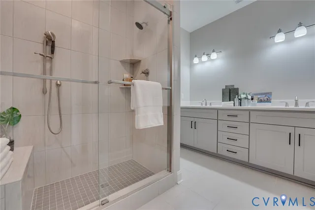 a bathroom with a double vanity sink a shower and a mirror