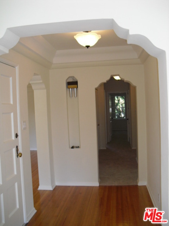 9963 Durant Drive Beverly Hills, CA 90212 - Photo 4 of 23 a view of a hallway with wooden floor and staircase
