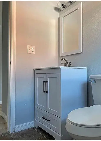 a bathroom with a toilet a sink and mirror