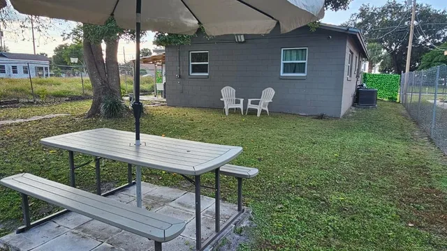 a view of a backyard with table and chairs under an umbrella
