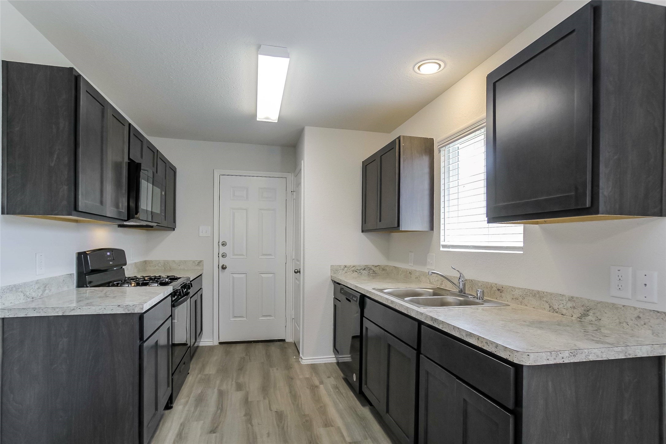 22382 Clear Castle Drive Porter, TX 77365 - Photo 3 of 14 a kitchen with a sink stove and microwave