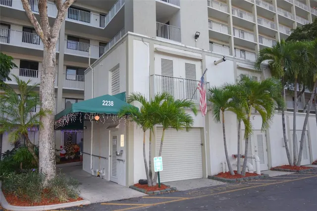a front view of a building with palm trees