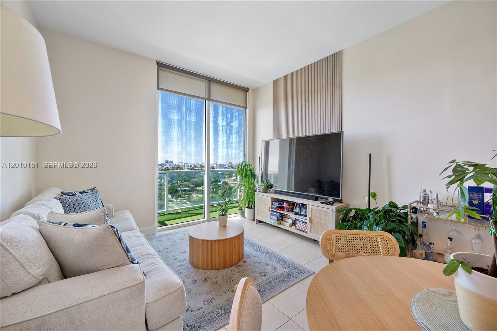 2525 Southwest 3rd Avenue, Unit 1603 Miami, FL 33129 - Photo 6 of 20 a living room with furniture a flat screen tv and a large window