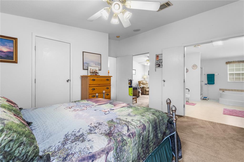 12251 Southeast 66th Place Morriston, FL 32668 - Photo 29 of 55 a bedroom with a bed and a chandelier