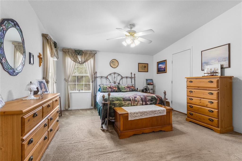 12251 Southeast 66th Place Morriston, FL 32668 - Photo 30 of 55 a bedroom with a bed and a chandelier