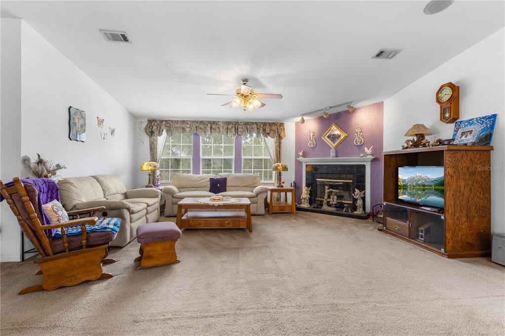 12251 Southeast 66th Place Morriston, FL 32668 - Photo 34 of 55 a living room with furniture and a fireplace