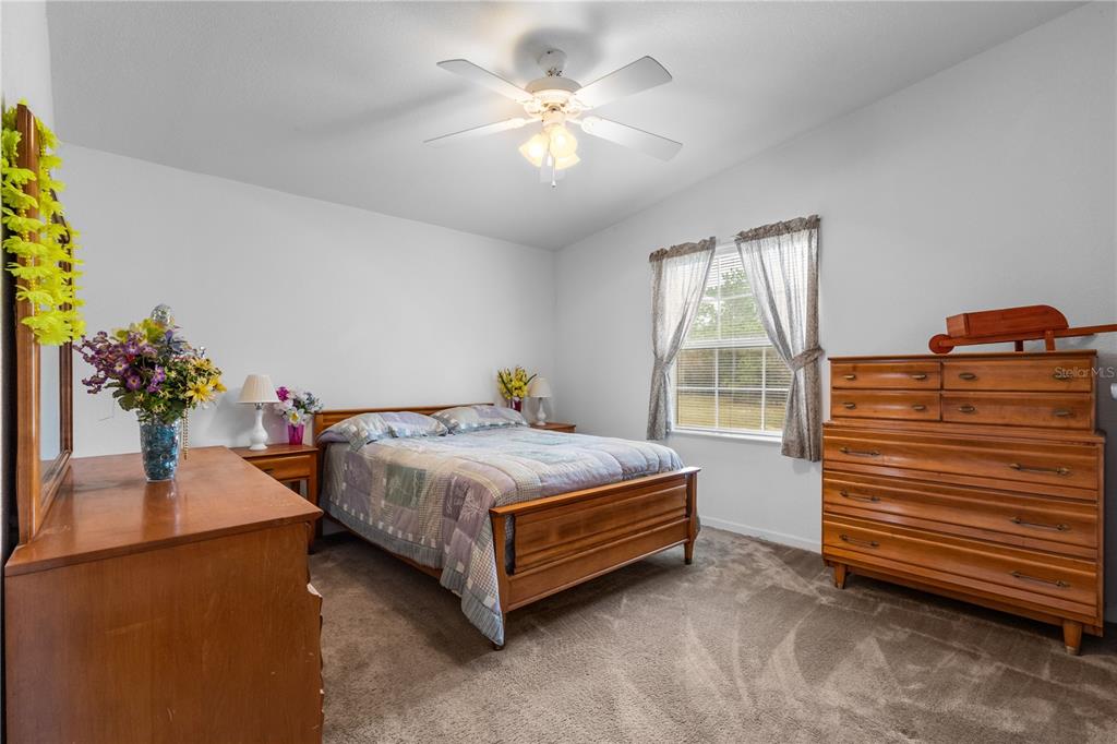 12251 Southeast 66th Place Morriston, FL 32668 - Photo 38 of 55 a bedroom with a bed and a chandelier