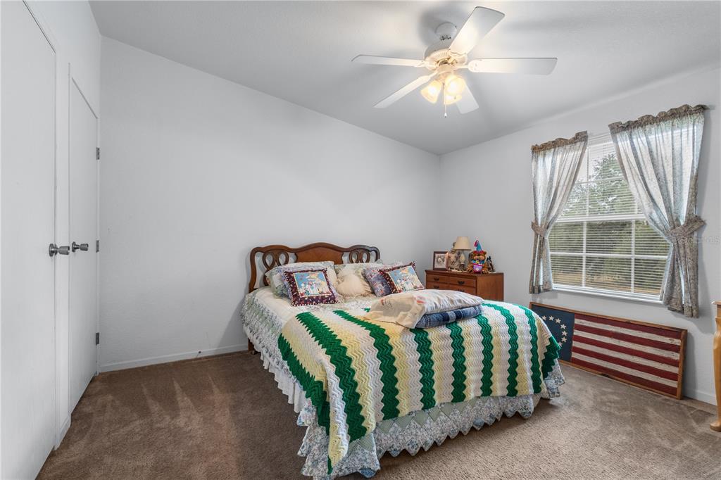 12251 Southeast 66th Place Morriston, FL 32668 - Photo 40 of 55 a bedroom with a bed and a chandelier