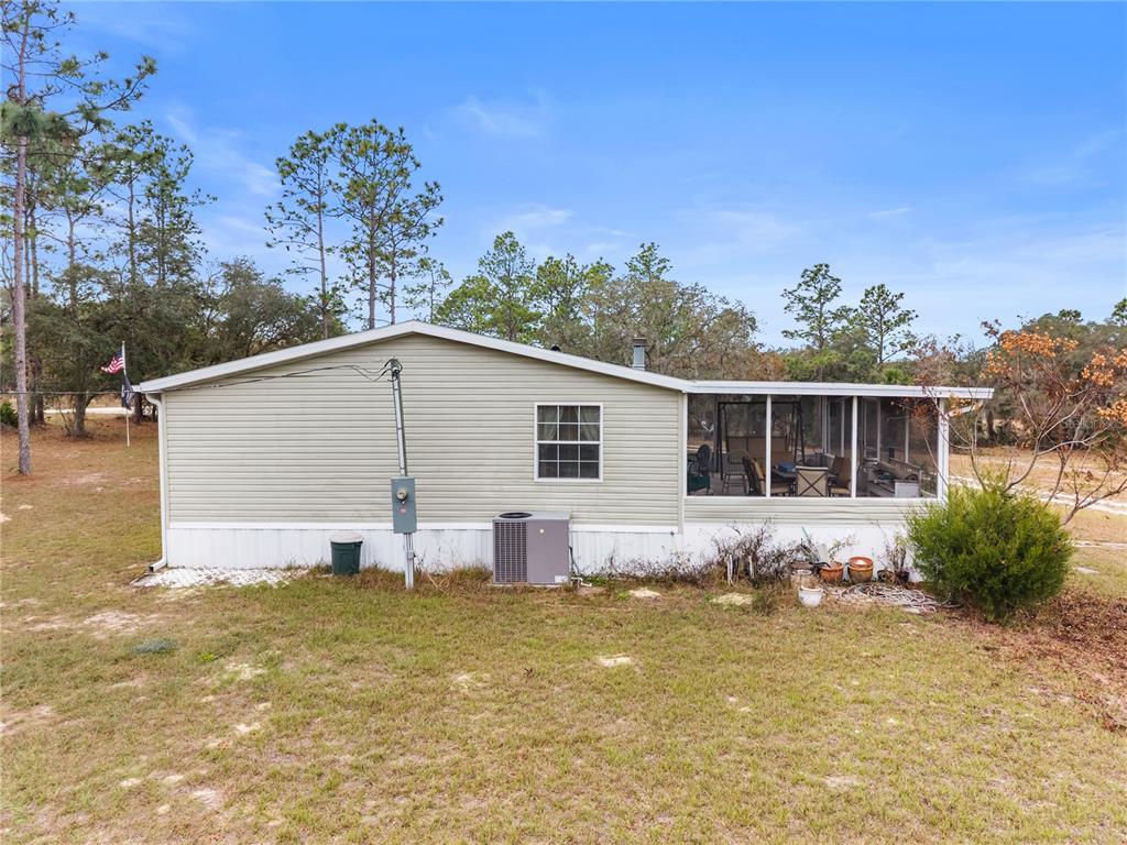 12251 Southeast 66th Place Morriston, FL 32668 - Photo 4 of 55 a view of house with backyard and seating area