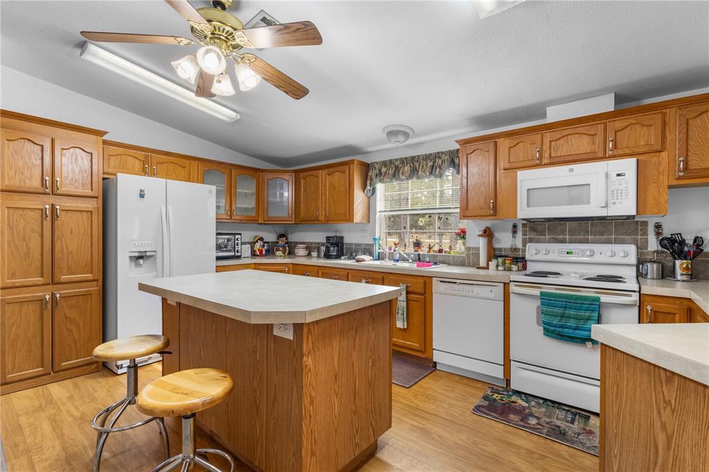 12251 Southeast 66th Place Morriston, FL 32668 - Photo 44 of 55 a kitchen with stainless steel appliances granite countertop a sink a stove and a refrigerator